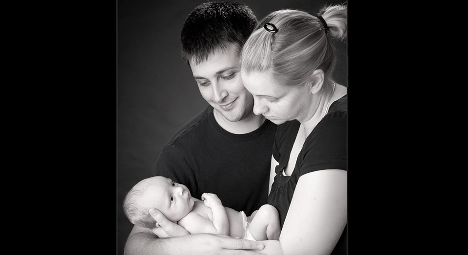 First family photo of couple with newborn baby