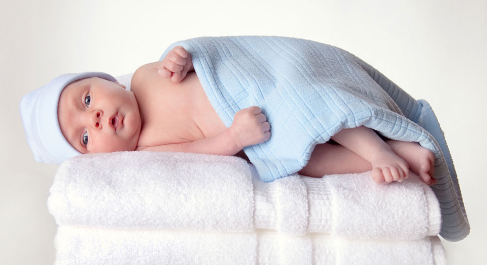 Baby on soft towels in a newborn professional photograph