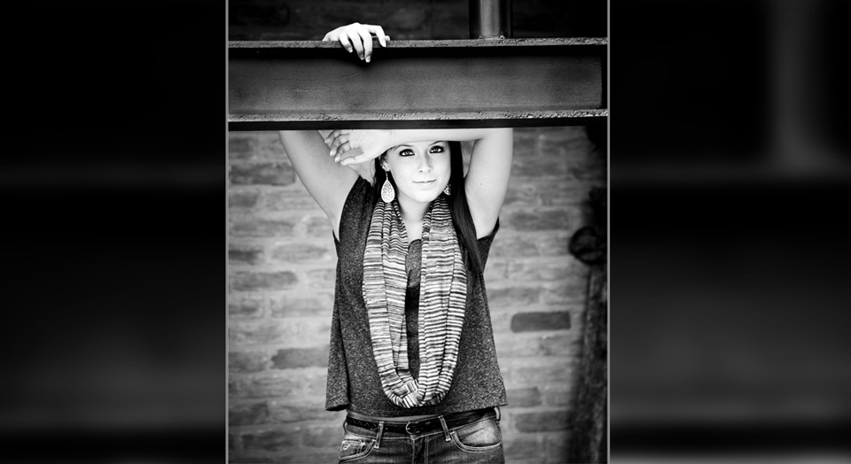 Hudsonville High School Senior Photography in a urban warehouse setting with dark welded overhead support beams